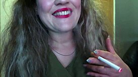 Cute woman paints her lips red and smokes a cigarette. I hope you like it.