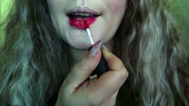 Cute woman paints her lips red and smokes a cigarette. I hope you like it.