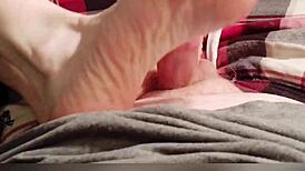 Amateur redhead gives footjob while watching tv