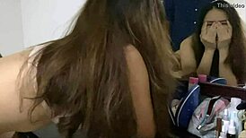 Beautiful Thai girl poses in mirror