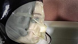 fetish leather girl in bondage play, wrapped in nylon, latex, hood, catsuit, and rubber for intense mummification.