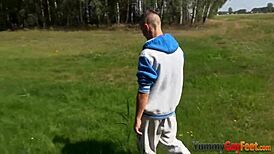 I see gay twink jacking off and cumming with footjob outdoors