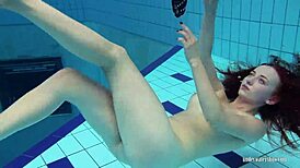 Redheaded Katrin Strips Underwater in Teasing Solo with Ripped Clothes and Tattoos