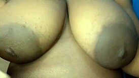 ebony woman gently touches her big busty breasts