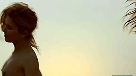 Patru prietene lesbiene se dezbracă și se joacă una cu alta pe plajă însorită.