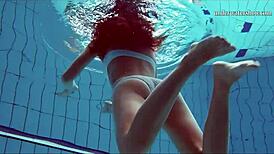 Teen brunette's hot tits and shaved pussy underwater.