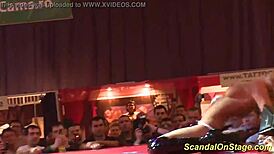 Look at this busty MILF ripping clothes on stage for a public striptease!