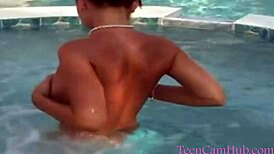 A young model teases with big tits by the pool in a bikini