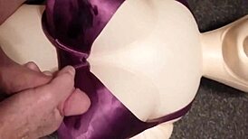 Dolly gives handjob in bra, ending with cumshot.