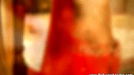 A brunette milf performs a seductive striptease, ripping clothes and undressing slowly