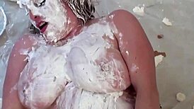 Maggie Green pleasures herself with a dildo, her big natural tits smeared in cream.