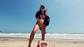 Teen brunette masturbates publicly on nude beach, caressing feet while guy jerks off and cums