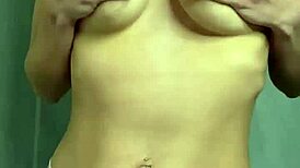 En student kjærtegner sine naturlige bryster hjemme