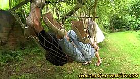 Two lesbians engage in pissing play with a toy outdoors, involving masturbation and fingering