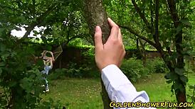 Two lesbians engage in pissing play with a toy outdoors, involving masturbation and fingering