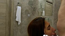 the horny teen kneels to suck and deepthroat a big cock with her small tits bouncing