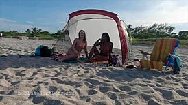 two brunettes giving double handjob on public beach fun