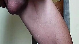 Muscular bodybuilder cums in front of the mirror.