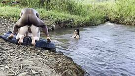 Sex în aer liber lângă râu sub soare! Două fete fierbinți sug și primesc creampie dur!