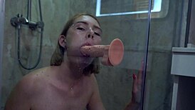 babe casually sucks dildo and fucks her shaved pussy in the shower