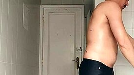 sexy guy shaving in black beach shorts