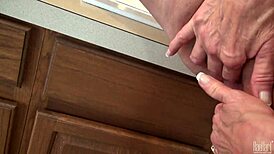 Mature housewife Raehart experiences pure pleasure in the kitchen, showcasing her big tits in uniform while engaging in intimate acts