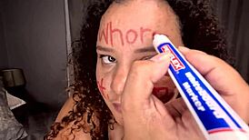 bbw colored girl deepthroating a dildo after writing dirty words on her whore face