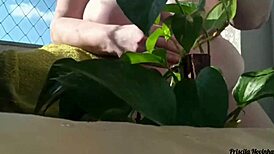 Naked Woman Waters Plants on Balcony for Curious Viewers