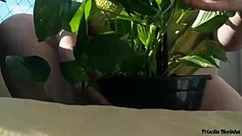 Naked Woman Waters Plants on Balcony for Curious Viewers