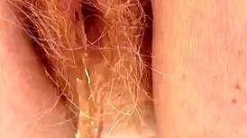 Redhead pees through her hairy pussy in this raw fetish scene.