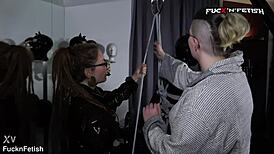 Latexboy rigged and caressed intensely in backstage humiliation