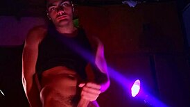 muscular bodybuilder strokes massive cock in purple orange shadows