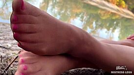 on the autumn river bank, my cute feet tease in nude tights rubbing together