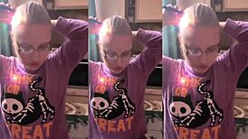 asmr blonde with glasses brushes long hair using lollipop, headphones on.