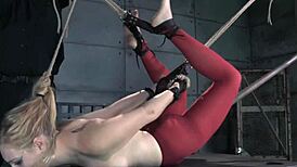 Stockinged bdsm hogtied sub endures rough caning in pillory machine torment