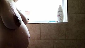 Damn, watch pregnant babe shave her wet pussy in sudsy shower!